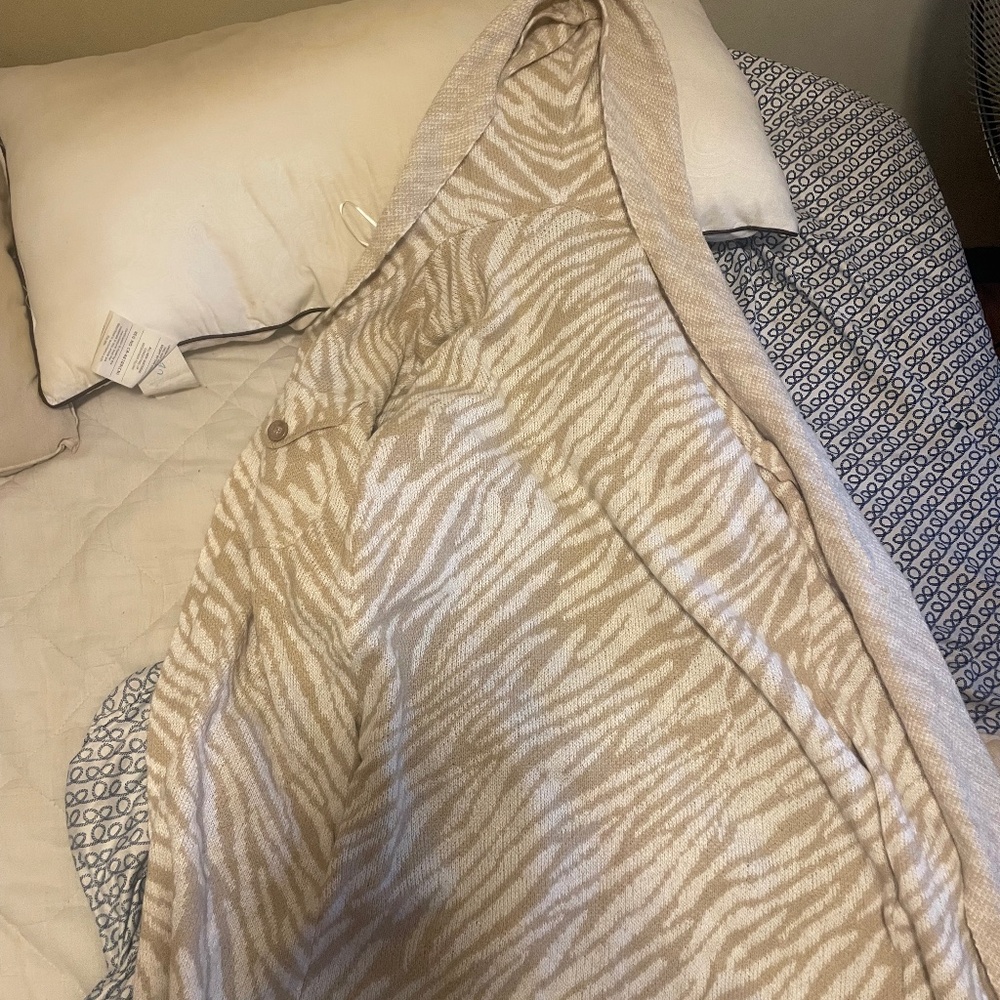 hooded cardigan or sweater with a beige and white zebra or animal print pattern.
